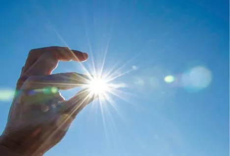fingers holding sun