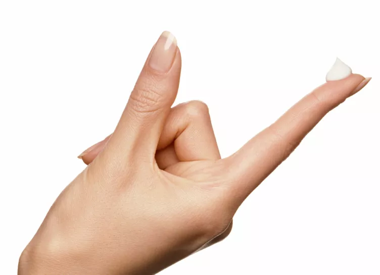 hand with a bit of topical cream at the end of a finger tip